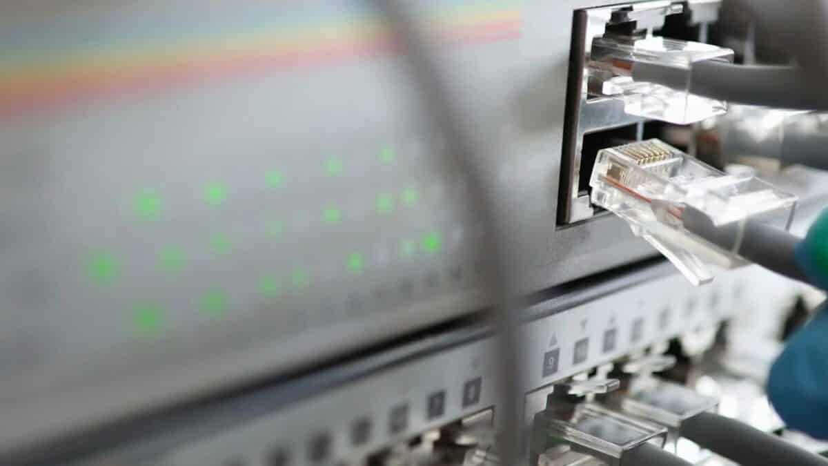 Netzwerktechnik - CAT-Kabel wird in Buchse eines NetzwerkSwitches gesteckt