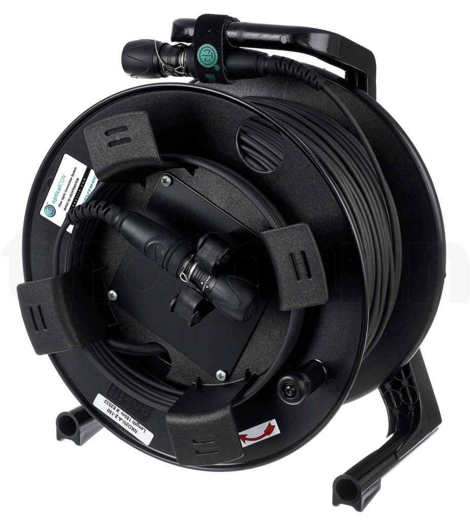 Eine schwarze Glasfaser-Kabeltrommel mit mehreren Stickern drauf. Auf den Stickern stehen die Länge und der Typ des Kabels.